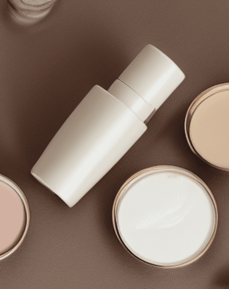 A portrait crop of a routine bottle and cream jars arranged on a warm editorial brown surface.